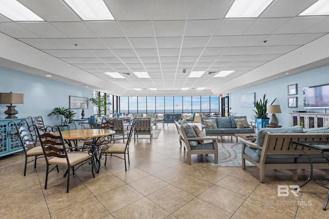 tiled living room featuring a paneled ceiling