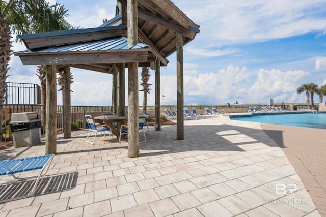 view of terrace with a grill and a community pool