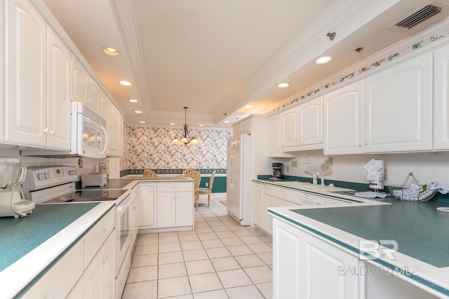 kitchen with hanging light fixtures, white appliances, a tray ceiling, and backsplash