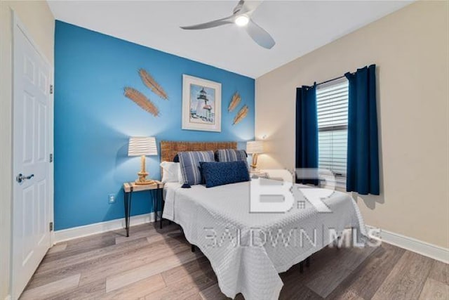 bedroom with a ceiling fan, baseboards, and wood finished floors