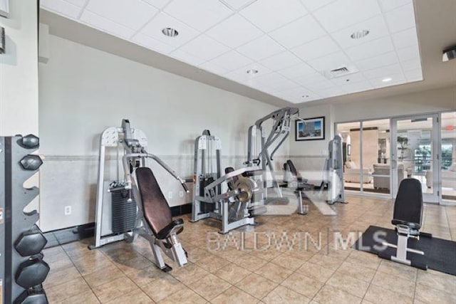 workout area with french doors, a drop ceiling, tile patterned flooring, and visible vents