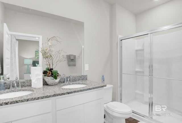 bathroom featuring vanity, an enclosed shower, and toilet