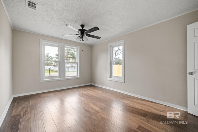 empty room featuring hardwood / wood-style flooring, plenty of natural light, and a textured ceiling