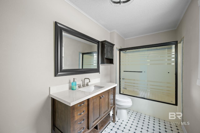 full bathroom with bath / shower combo with glass door, vanity, a textured ceiling, crown molding, and toilet