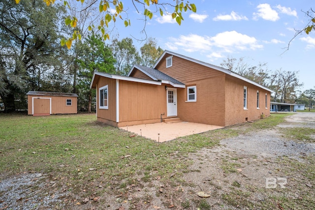 back of house with a yard, a patio, and a storage unit