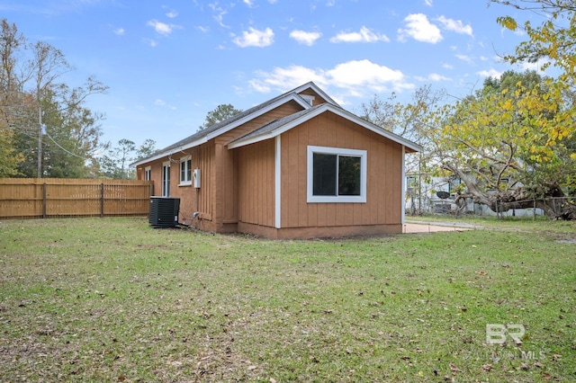 view of property exterior with central air condition unit and a yard