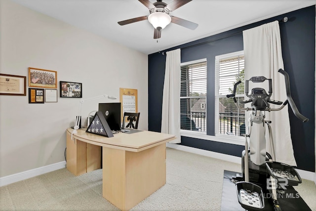 office space featuring light carpet, ceiling fan, and baseboards