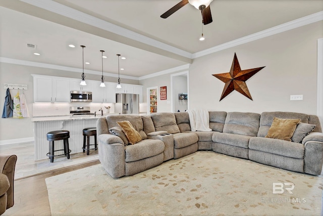 living area with light wood-style flooring, recessed lighting, visible vents, a ceiling fan, and ornamental molding