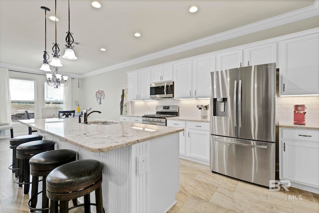 kitchen featuring crown molding, appliances with stainless steel finishes, a kitchen island with sink, a sink, and white cabinetry