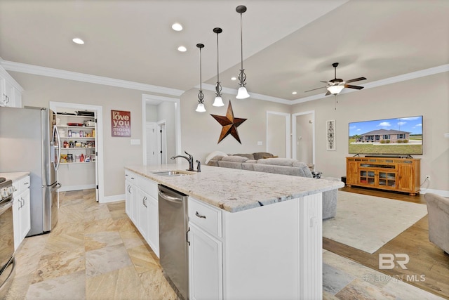 kitchen with crown molding, appliances with stainless steel finishes, open floor plan, and a sink