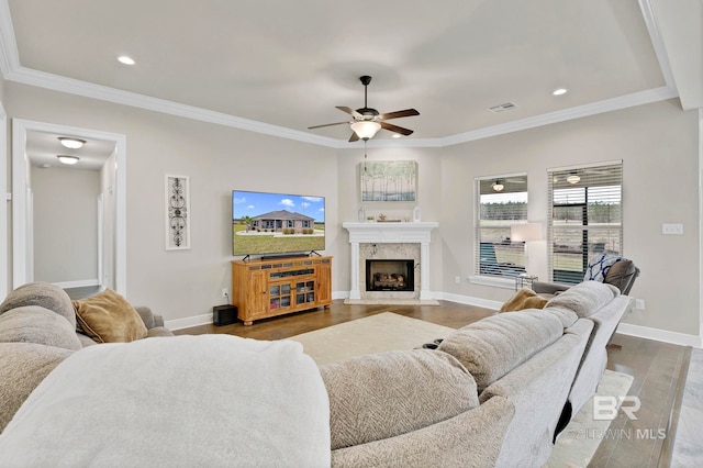 living room featuring ornamental molding, a fireplace, wood finished floors, and visible vents