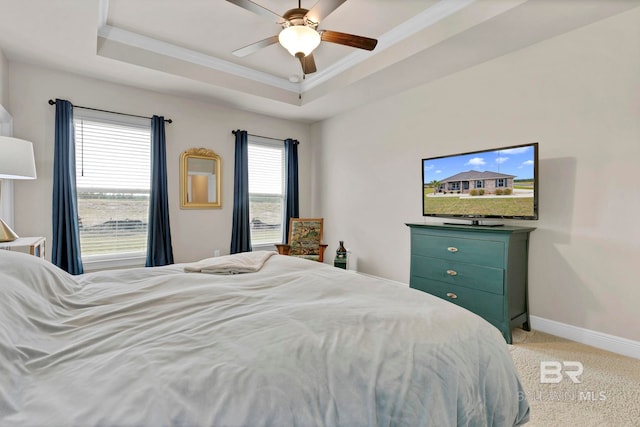 bedroom with light carpet, a ceiling fan, baseboards, ornamental molding, and a raised ceiling