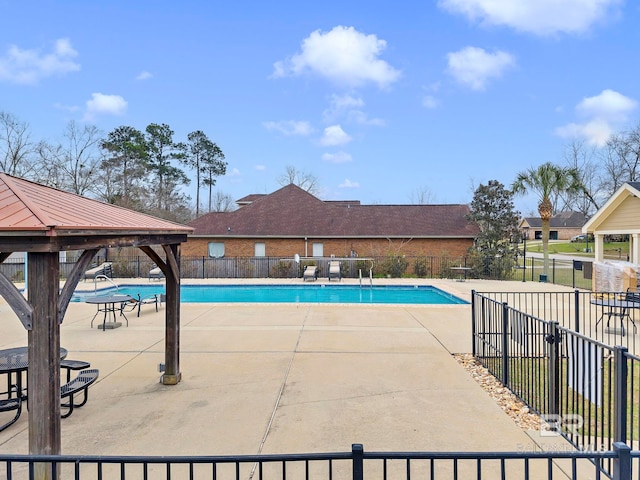 community pool featuring a patio area, fence, and a gazebo