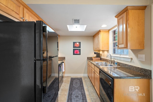 kitchen with light tile patterned floors, visible vents, a sink, black appliances, and baseboards