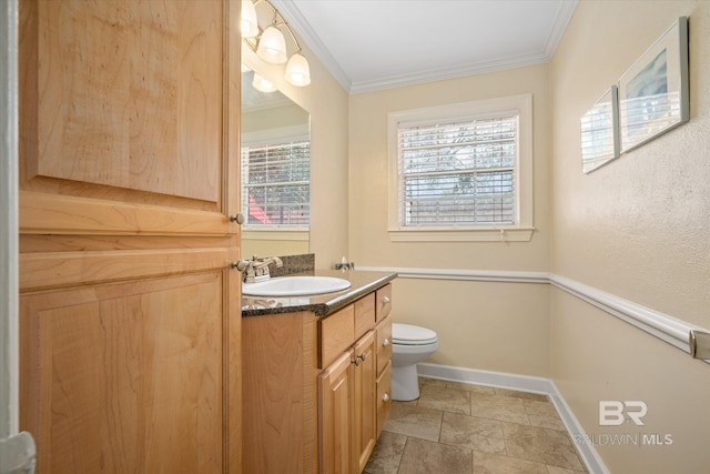 half bathroom with toilet, ornamental molding, stone finish flooring, vanity, and baseboards