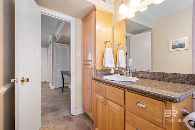 bathroom featuring baseboards, vanity, visible vents, and crown molding