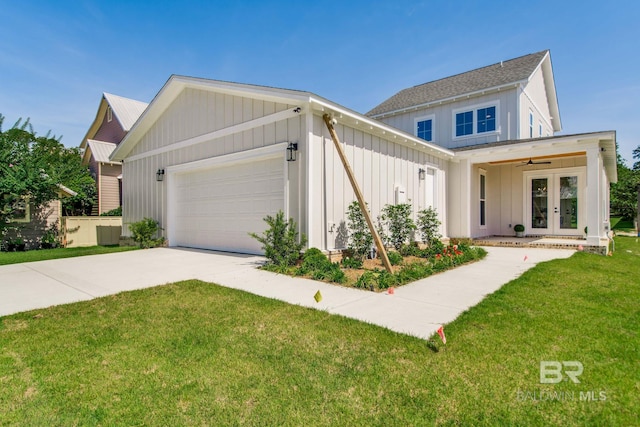 15132 Itea Dr, Foley, AL 36535 - modern farmhouse with french doors, board and batten siding, an attached garage, a front yard, and concrete driveway