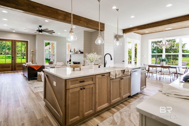 15132 Itea Dr, Foley, AL 36535 - kitchen with beam ceiling, light countertops, open floor plan, a kitchen island with sink, and light wood-style floors
