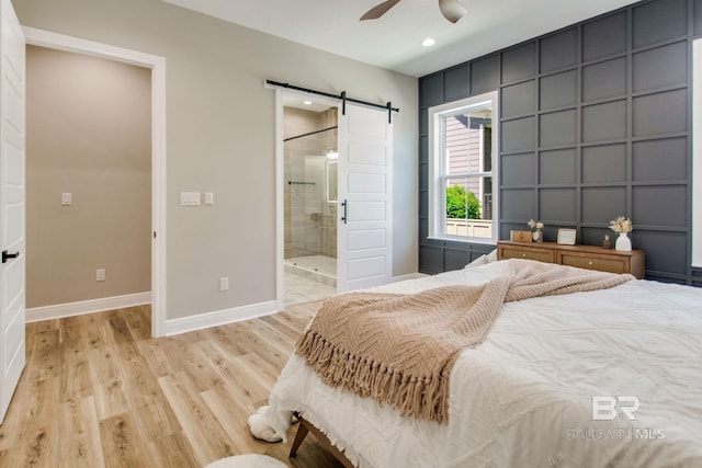 15132 Itea Dr, Foley, AL 36535 - bedroom featuring a barn door, light wood finished floors, recessed lighting, a decorative wall, and ensuite bathroom