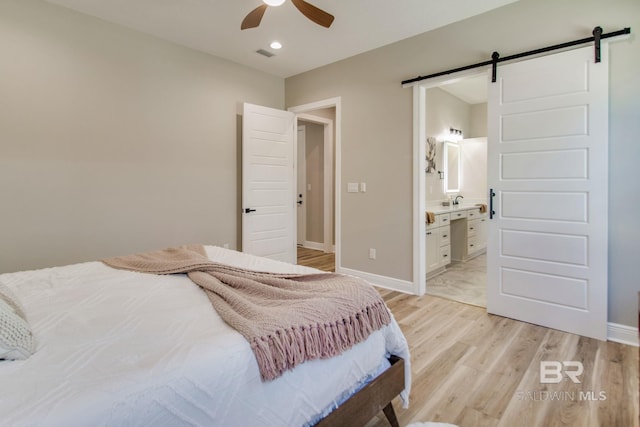 15132 Itea Dr, Foley, AL 36535 - bedroom with a barn door, light wood-style flooring, recessed lighting, connected bathroom, and ceiling fan