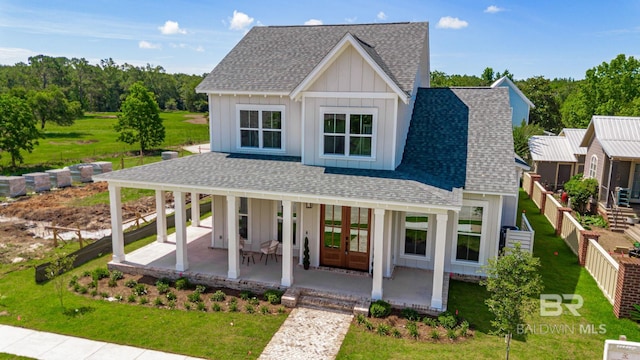 15132 Itea Dr, Foley, AL 36535 - modern farmhouse style home with board and batten siding, roof with shingles, a front lawn, french doors, and covered porch