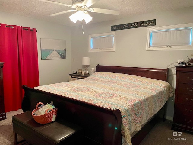 carpeted bedroom with ceiling fan and a textured ceiling