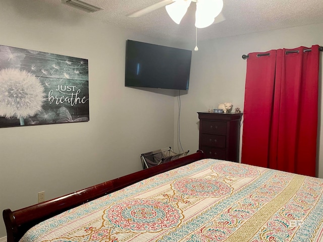 bedroom with ceiling fan and a textured ceiling