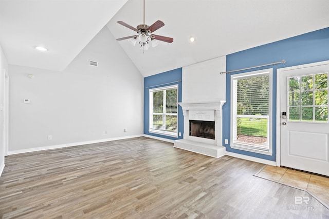 unfurnished living room with ceiling fan, high vaulted ceiling, and light wood-type flooring