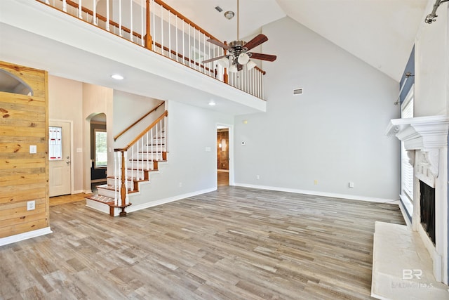 unfurnished living room featuring ceiling fan, high vaulted ceiling, and light hardwood / wood-style flooring