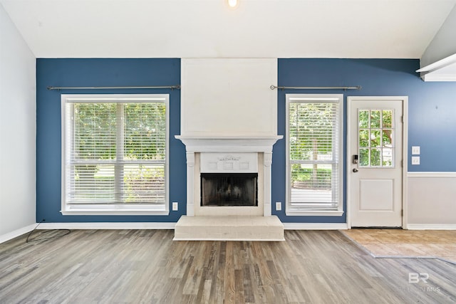 unfurnished living room with lofted ceiling and light wood-type flooring