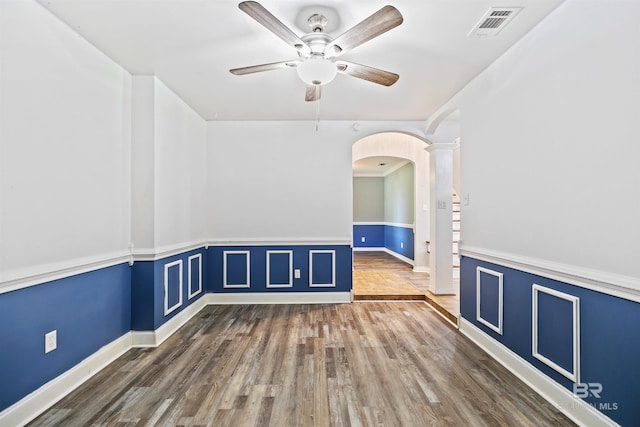 spare room with ceiling fan, dark hardwood / wood-style flooring, and ornate columns