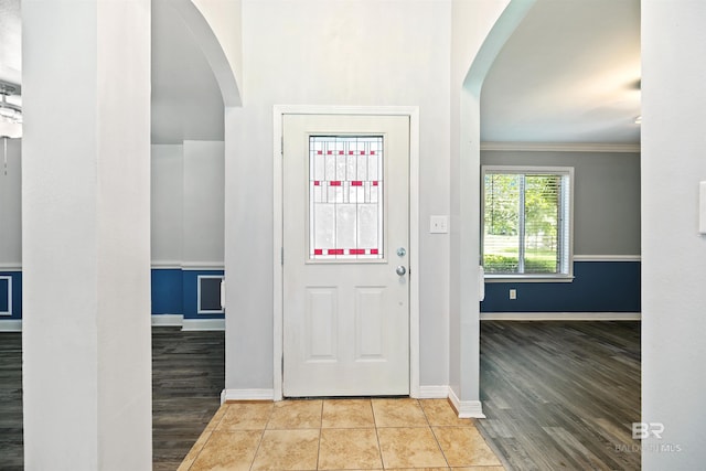 foyer featuring light tile patterned floors and ornamental molding