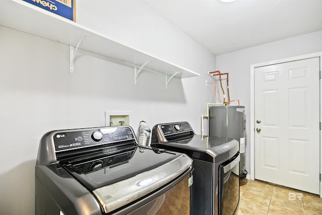 washroom with washing machine and clothes dryer and water heater