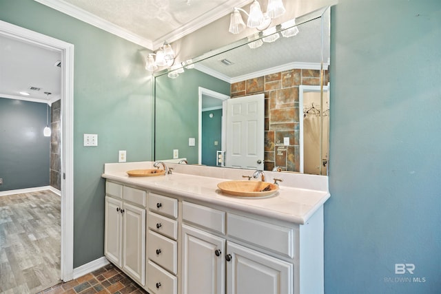 bathroom featuring a textured ceiling, vanity, and crown molding