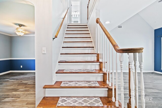 staircase with crown molding and hardwood / wood-style flooring