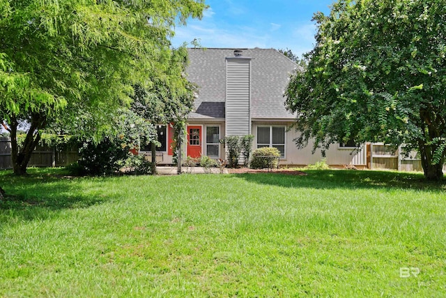 rear view of property featuring a yard