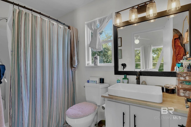 bathroom with a shower with shower curtain, ceiling fan, toilet, and vanity