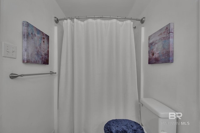 bathroom featuring a shower with shower curtain and toilet