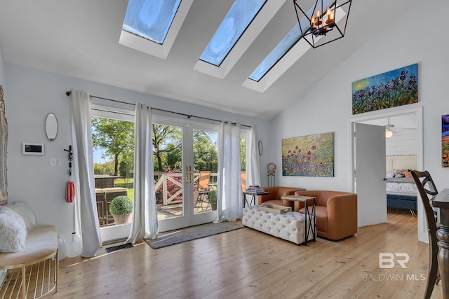 interior space with french doors, light hardwood / wood-style flooring, high vaulted ceiling, and an inviting chandelier