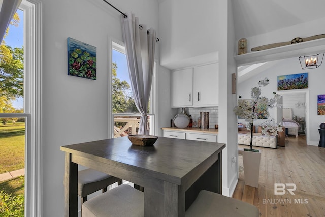 dining area featuring light hardwood / wood-style floors, lofted ceiling, and a chandelier