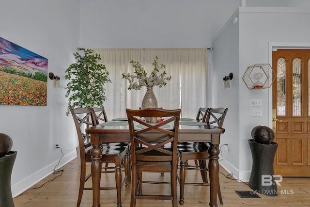 dining space featuring hardwood / wood-style floors and crown molding