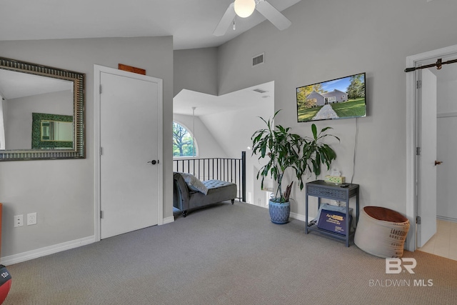 living area featuring light colored carpet, vaulted ceiling, and ceiling fan