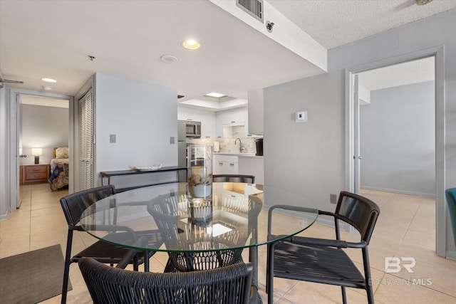 dining area featuring visible vents, baseboards, and light tile patterned flooring