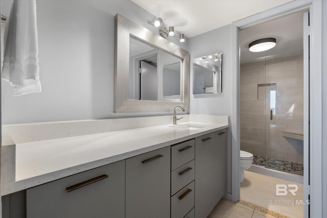 bathroom featuring a stall shower, tile patterned flooring, vanity, and toilet