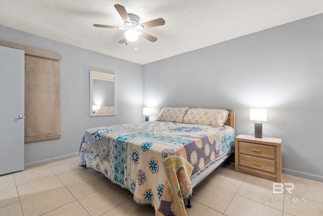 bedroom with light tile patterned floors, a textured ceiling, and baseboards