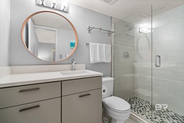 full bath with a stall shower, vanity, and toilet