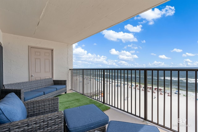 balcony with a water view and a view of the beach