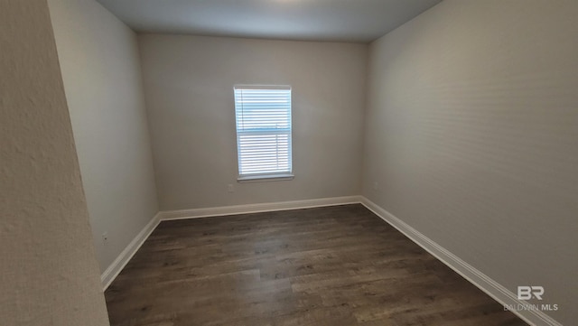 unfurnished room featuring dark wood-type flooring