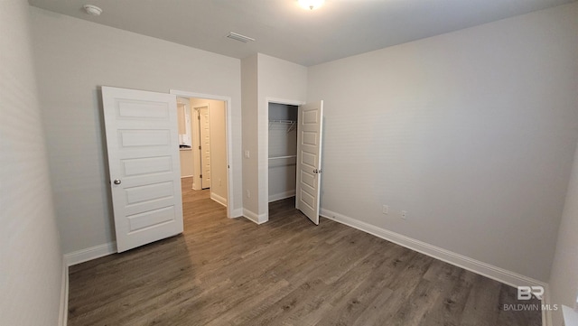 unfurnished bedroom featuring dark hardwood / wood-style flooring and a closet