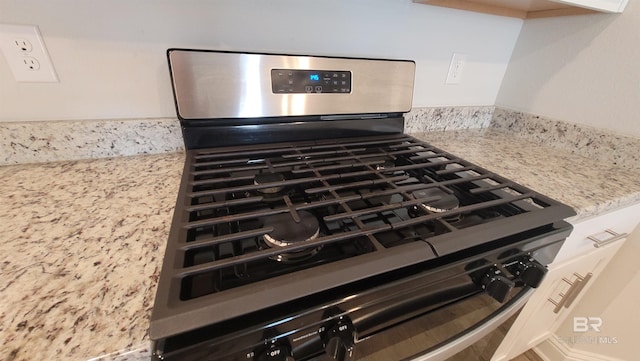 room details with light stone counters and stainless steel range with gas cooktop